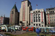 The Bund aka Zhong Shan Road. View along the 1930s style waterfront architecture including the Peace Hotel and the Bank of China from park with modern sculpture in the foreground