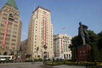 The Bund aka Zhong Shan Road. 1930s style waterfront architecture including the Peace Hotel and the Bank of China with statue of Mao in the foreground