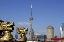 City skyline and Television Tower with golden dragon head statues in the foreground