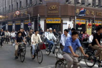 Mass of cyclists passing a crossroads at the traffic lights outside the Hui Luo Co. Ltd building