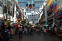 View along a covered market street lined with stallls