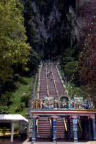 View of steep stairway leading up in to the caves with colourful statue covered arch at the bottom