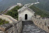 View along a section of the wall toward small rooved and walled building