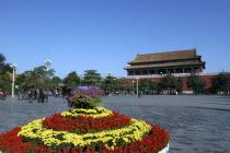 View over flowerbed and courtyard outside the walls of the complex toward one of the buildings