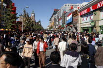 Busy commercial shopping area with clock tower in the distance