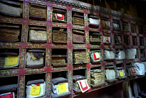 Scriptures on shelves with each pocket holding a chapter at Tikse Gompa