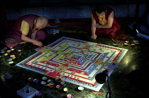 Two monks painting decorative patterns for the Pujar ceremony  and the making of a spiritual Mandala