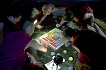 Several monks painting decorative patterns for the Pujar ceremony  and the making of a spiritual Mandala