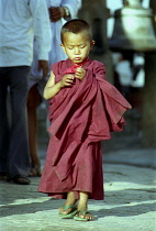 Young novice monk walking through a street