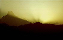 Mountain range in silhouette at sunset viewed from Poon Hill