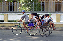 Cyclo transporting several children to or from school