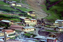 Aerial view over the towns rooftops with herd of  Yaks moving through the street