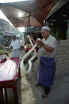 Man spinning dough at a street side stall