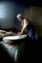 Smiling cook rolling pastry for an Apple Pie