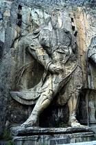 Ancient Longmen caves. One of the many beheaded images of Buddha and his disciples carved in to the cliff wall