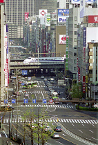 Bullet Train passing through the city on raised platform over a main road