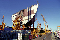 Dae-woos new ship building yard with ship section raised on scaffolding surrounded by cranes