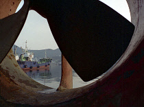 View of moored ship seen through large propeller