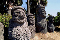 Tolharubang grandfather stones carved from lava rock which are guardians of the gates to Chejus ancient towns
