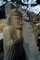 Carved Guardian Stones standing in a row at the Buddhist Temple