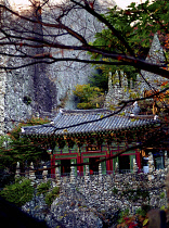 Mai Son Temple set against a backdrop of cliffs and surrounded by autumnal trees