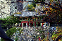 Mai Son Temple set against a backdrop of cliffs and surrounded by autumnal trees