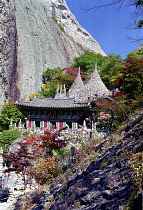 Mai Son Temple set against a backdrop of cliffs and surrounded by autumnal trees