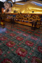 Wat Chayamangkalaram.  Interior with 32 metre long reclining Buddha lying behind display of various smaller figures and statues.