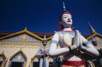 Wat Chayamangkalaram.  Exterior  temple statues with part view of rooftop and facade behind.