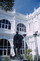 Penang Museum and Art Gallery.  Part view of white painted exterior with statue of Francis Light in the foreground.