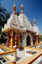 Dharmikarama Burmese Temple.  Exterior with ornate carved roof and statues.