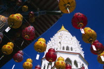 Ban Po  the Pagoda of a Thousand Buddhas. Tiered top with strings of red and yellow Chinese New Year lanterns hanging from overhanging roof in foreground.