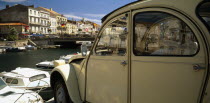 Sete.  Part view of harbour and waterside buildings with white citroen car in the foreground.
