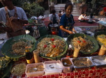 Wat Chettawan temple grounds with traditional Northern Thai food being served at a stallAsian Prathet Thai Raja Anachakra Thai Religion Siam Southeast Asia Classic Classical Historical Older Religiou...