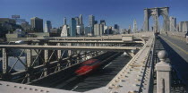Lower Manhattan.  Post September 11 skyline from Brooklyn Bridge with traffic and pedestrians crossing.