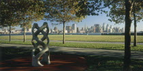 Lower Manhattan.  Post September 11 skyline seen from a public park in Hoboken  New Jersey with trees and modern sculpture in the foreground.
