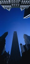 Midtown architecture seen from below looking upwards against cloudless blue sky.