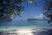 Pulau Singa Besar wildlife reserve island with tourists swimming in the clear water with offshore islandsAsian Malaysian Southeast Asia Beaches Holidaymakers Resort Sand Sandy Scenic Seaside Southern...