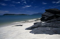 Pantai Tengah beach looking towards Pulau Rebak Besar island with rocks in the foregroundAsian Beaches Malaysian Resort Sand Sandy Seaside Shore Southeast Asia Tourism Scenic Southern