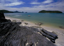 Pantai Tengah beach looking out to sea towards Pulau Tepor island with jet skiers and speedboats offshore
