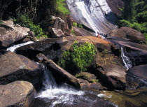 Telaga Tujuh Seven Wells Waterfall with female tourist sitting on rocks