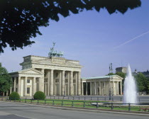 Brandenburg Gate showing the front and one side with a fountain in the foreground