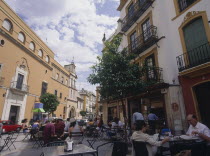 Santa Cruz District  Calle Santa Maria la Blanca with people sitting at tables outside restaurants and bars