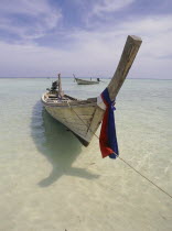 Lobagao Bay on the north of the island with a longtail boat moored off the beach