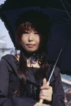 Harajuku District. Portrait of a teenage girl dressed in black with a black parasol