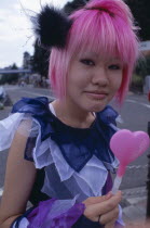 Harajuku District. Portrait of a teenage girl with pink hair and several facial piercings