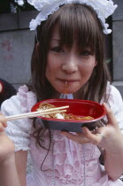 Harajuku District. Portrait of young teenage girl eating noodles
