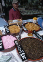 Tsukiji Fish Market stall with variety of seafood items on dispay and vendor in the background