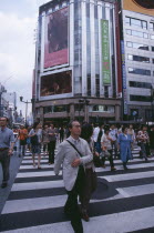 Ginza. Busy pedestrian crossing with city architecture behind