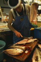 Tsukiji Fish Market with man slicing a fish in half
